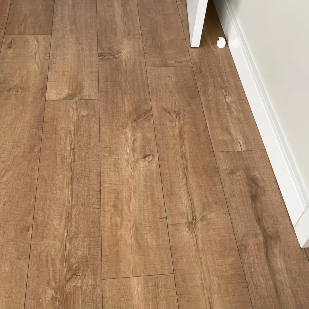 Piso laminado com rodapé branco instalado